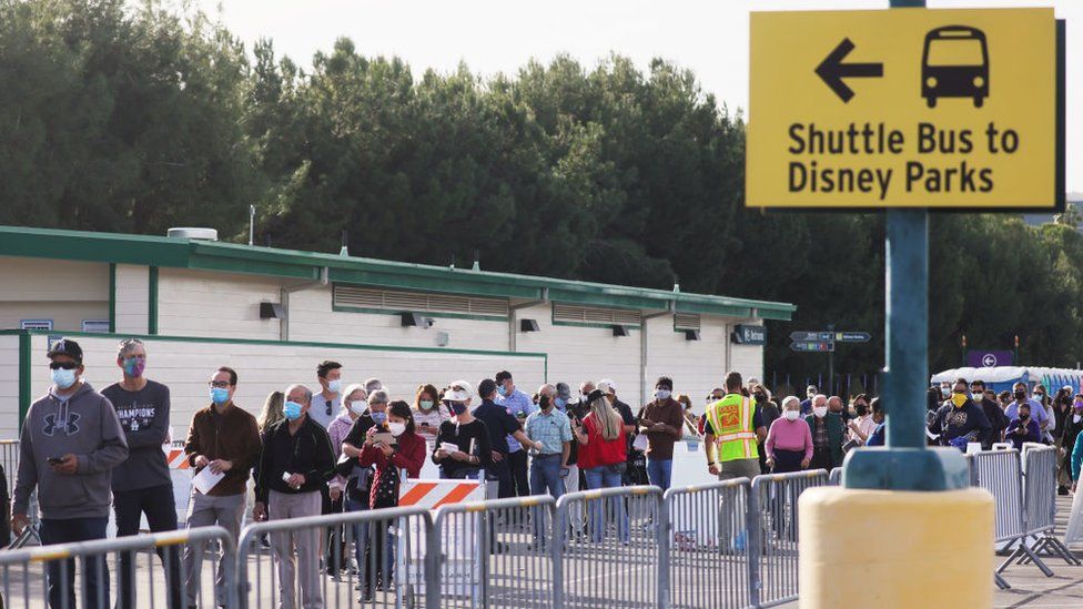 People wait in line to receive the Covid-19 vaccine at a mass vaccination site in a parking lot for Disneyland Resort