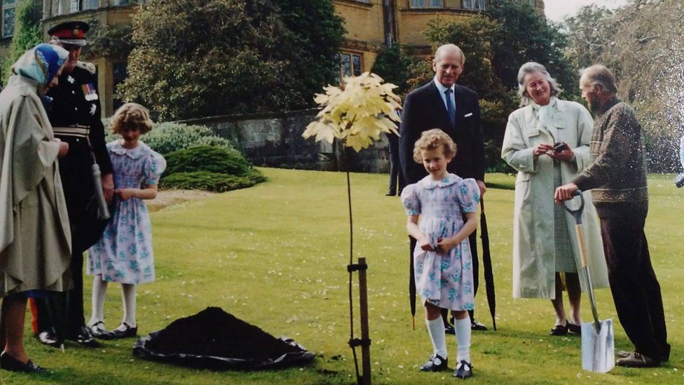 The Queen planting a tree at Minterne House in Dorset surrounded by members of the Digby family