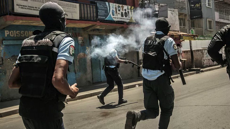 Police running down the street using tear gas