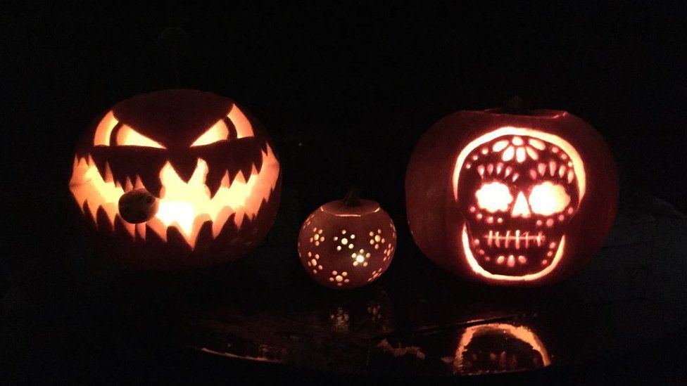 Pumpkins, lit from within, with monstrous faces