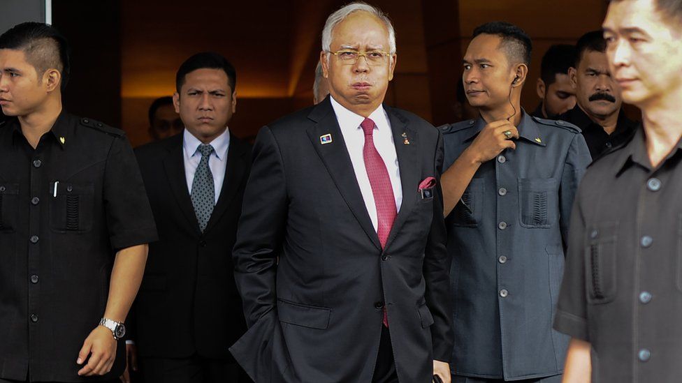 Malaysia' Prime Minister Najib Razak (C) reacts as he walks towards his car after attending a parliamentary session in Kuala Lumpur on 26 January 2016