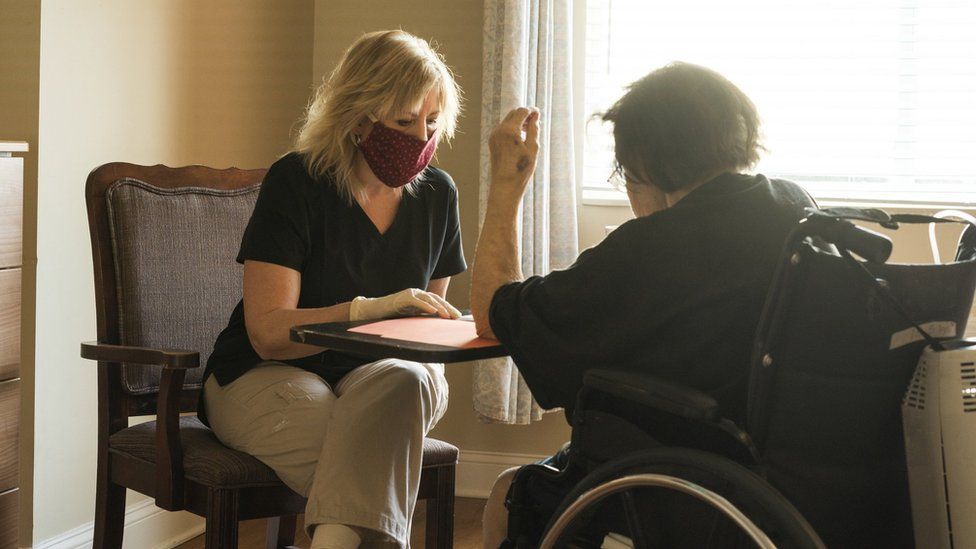 Care worker in mask and gloves