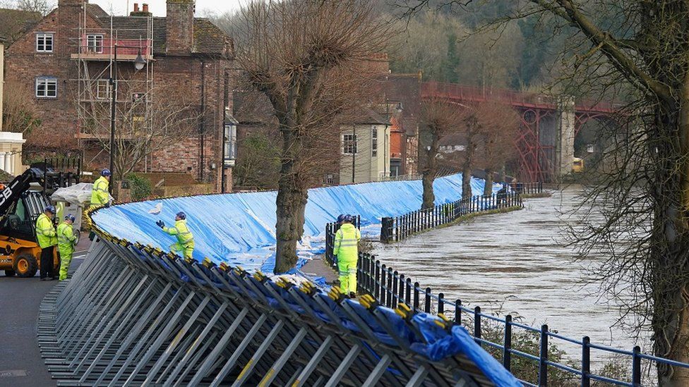 The swollen River Severn, as flood defenses are put in place along the Wharfage at Ironbridge in Telford. Picture date: Thursday January 12, 2023
