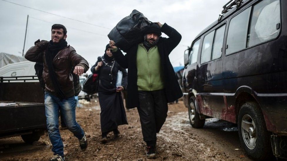 Syrian refugees arrive near the Turkish border, after fleeing fighting in Aleppo, 6 February