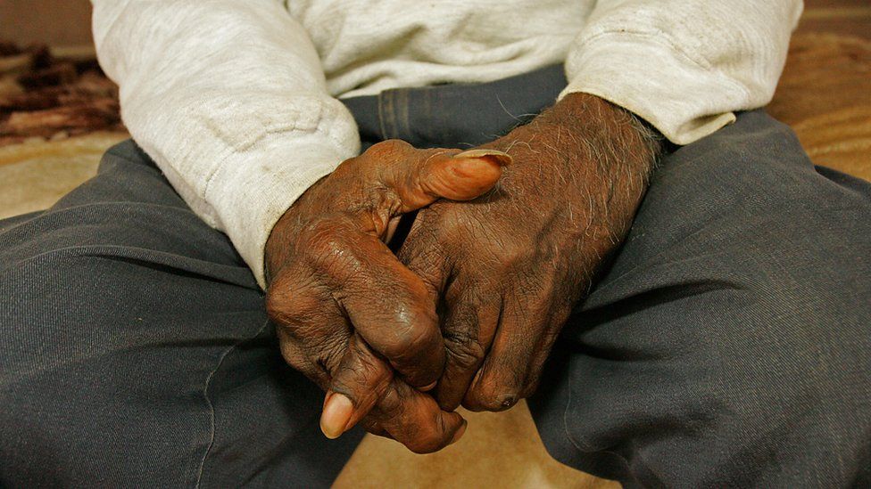 Man sits with hands clasped