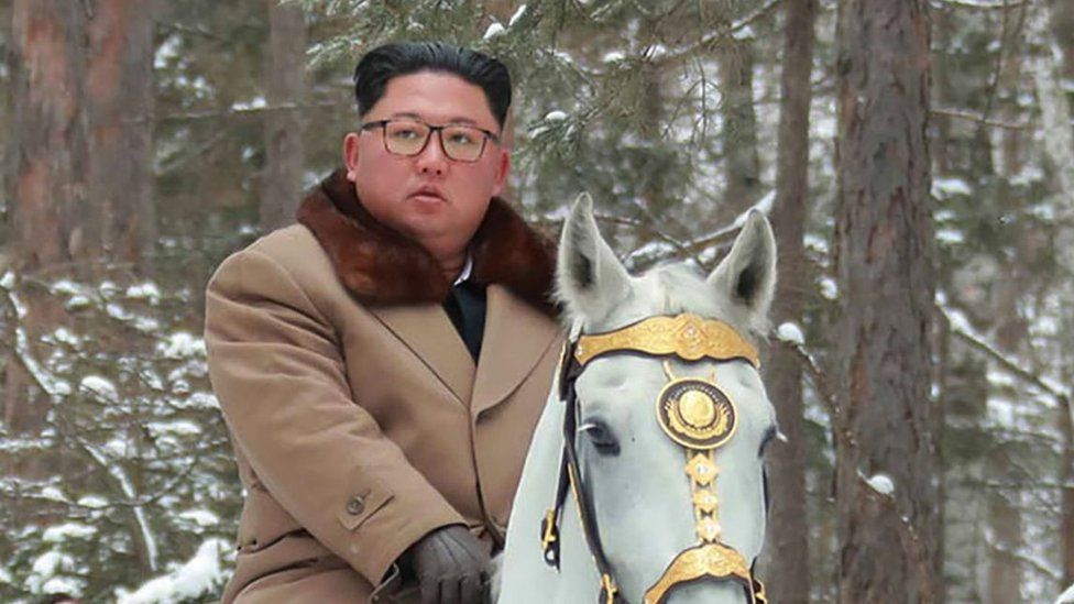 Kim Jong-un and his wife and officials riding horses through the snow in North Korea
