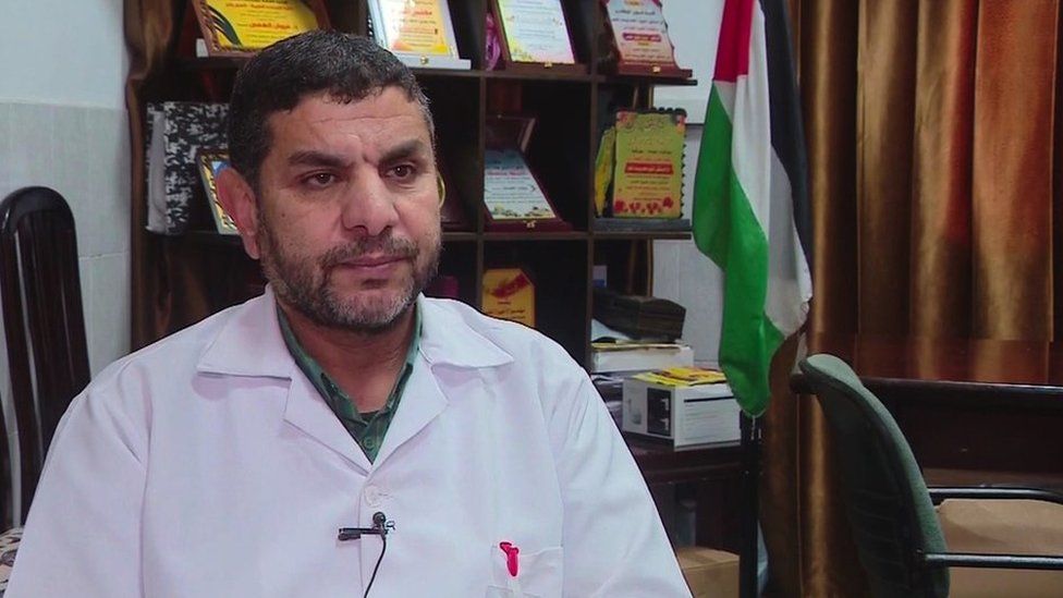Dr Marwan al-Hams wearing a medical coat and sitting down in his office at his hospital in Rafah