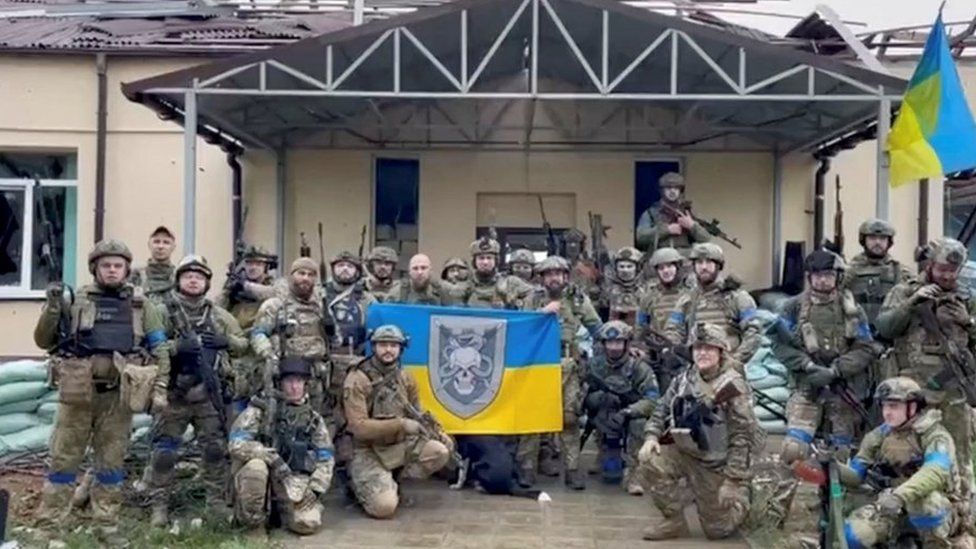 Ukrainian troops pose with flags in a village retaken from Russian control in the north-eastern Kharkiv region. Photo: 11 September 2022