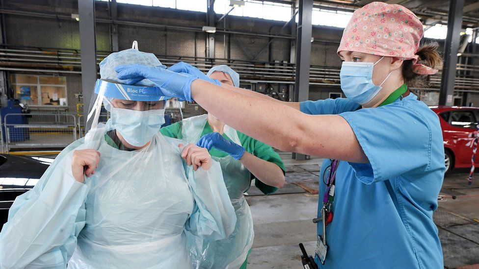 Nurses putting on PPE