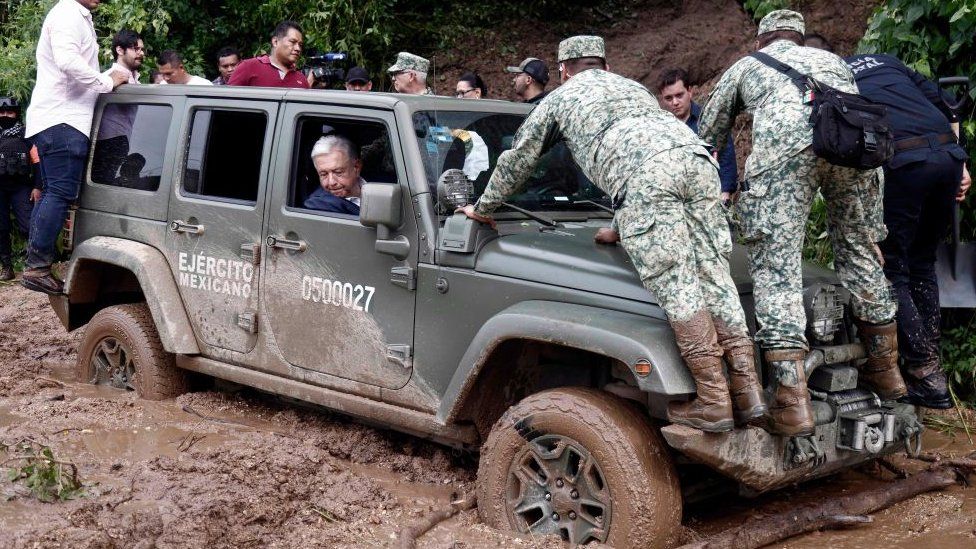 Mexican President Andres Manuel Lopez Obrador looks out of the window as the vehicle transporting his is stuck in mud during a visit to the Kilometro 42 community, near Acapulco, Guerrero State, Mexico, after the passage of Hurricane Otis, on October 25, 2023.