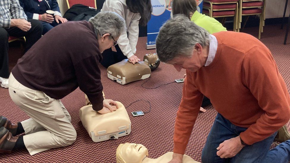 Two men giving CPR to dummies