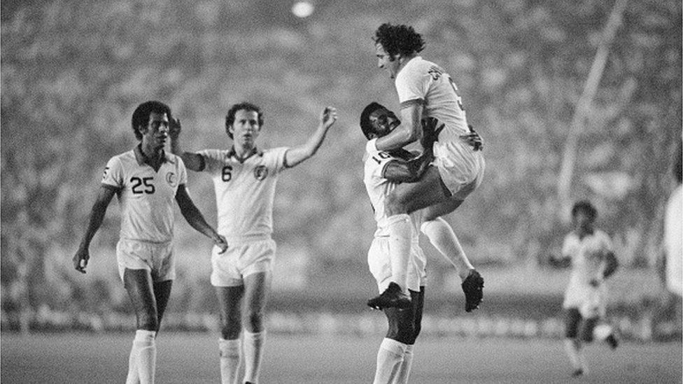 Brazilian soccer wizard Pele of New York Cosmos lifts up Giorgio Chinaglia in his arms after Chinaglia scored the Cosmos' first goal in "Pele Sayonara game" at Japan National Stadium. The New York Cosmos thrashed a Japanese National All-Star team 3-1. At the left is Franz Beckenbauer.