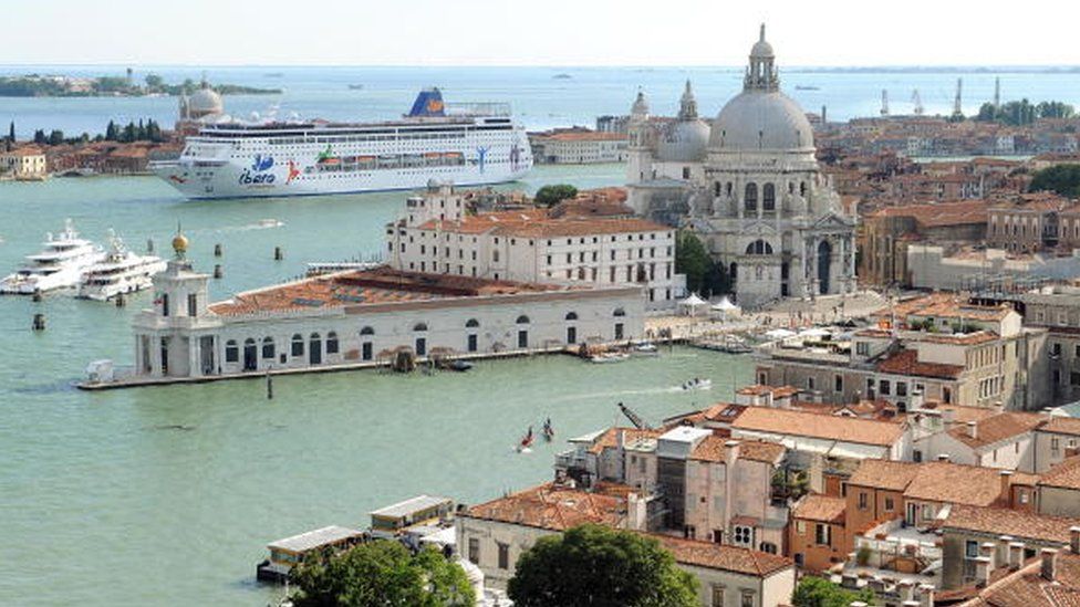 A cruise ship passes through the lagoon in Venice