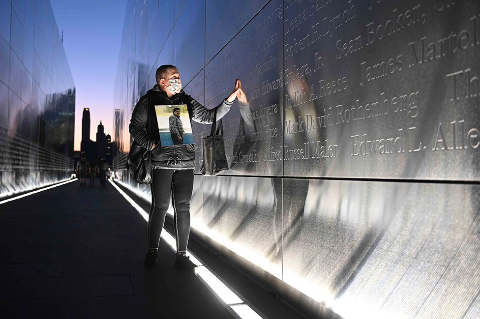 Claudia Castano touches the name of her brother German etched on a wall at the Empty Sky 9/11 Memorial in Liberty State Park in Jersey City, New Jersey, on the 20th anniversary of the terrorist attack