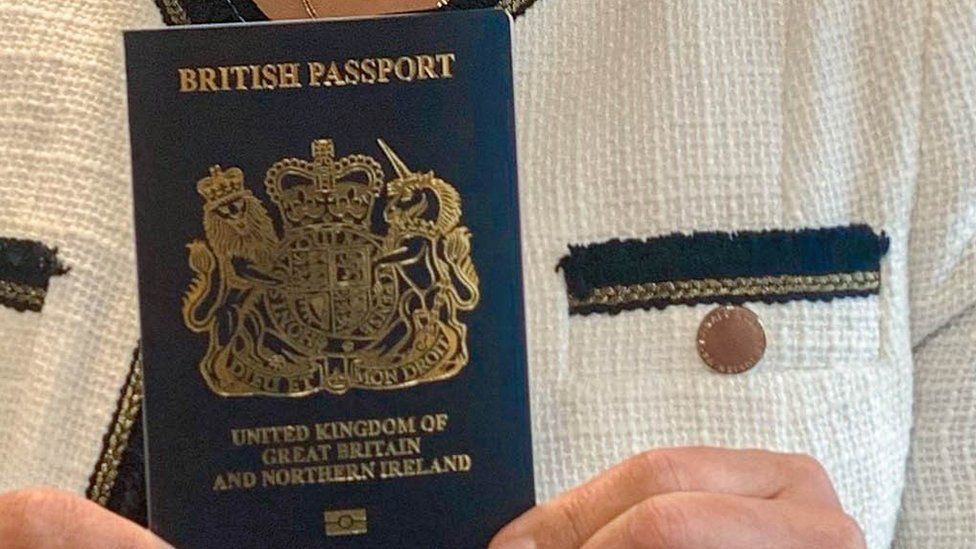 Home Secretary Priti Patel holding a blue passport