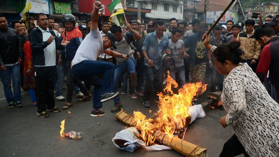 Indian supporters of the separatist Gorkha Janmukti Morcha (GJM) group shout slogans while burning an effigy of West Bengal Chief Minister Mamata Banerjee during an indefinite strike called in Darjeeling on June 19, 2017.