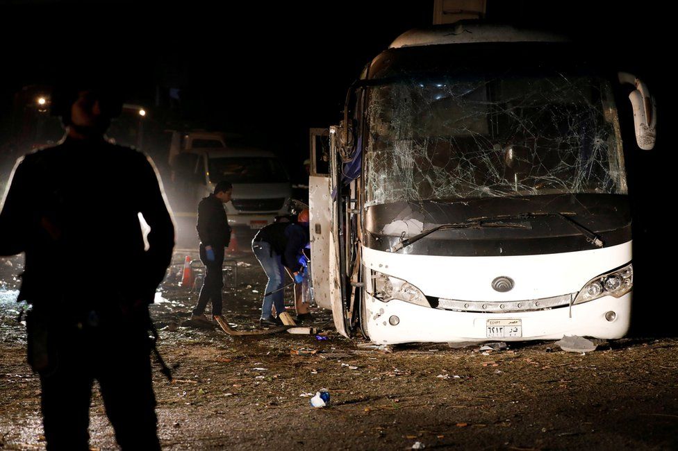 Police officers inspect the scene of a bus blast in Giza, Egypt, 28 December 2018