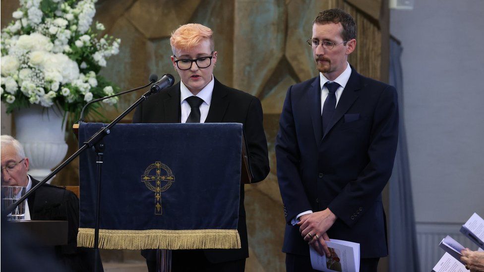 Victoria Trimble, accompanied by her brother Richard, giving a reading at the funeral