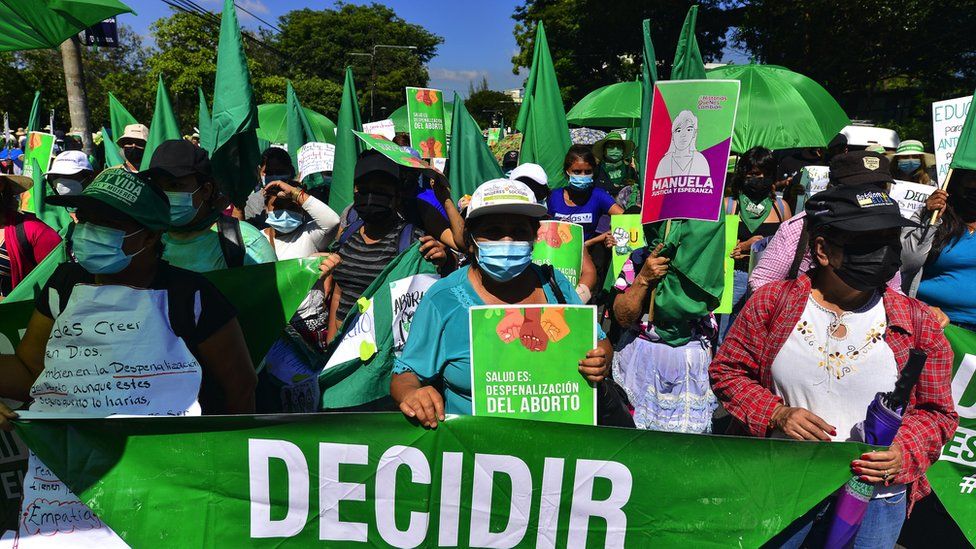 Women holding green umbrellas and signs at a protest in San Salvador, September 2021