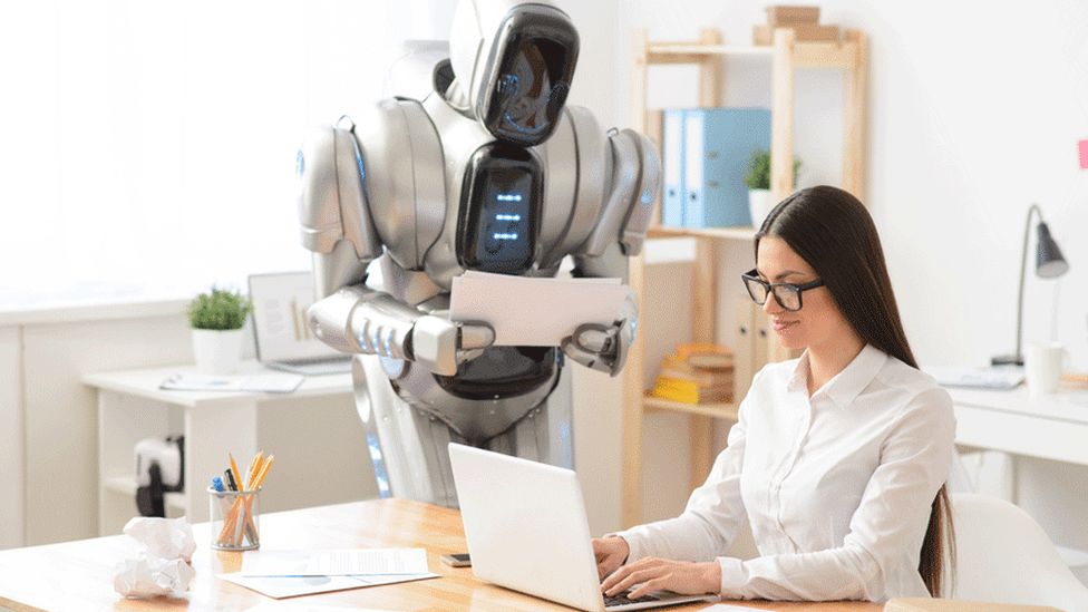 Robot and woman at a desk