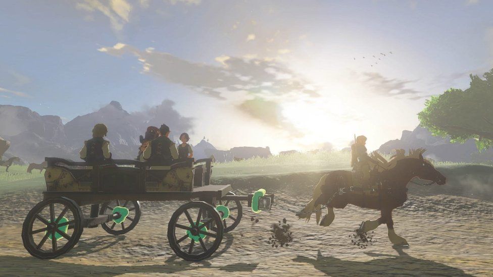 Link, on his horse, pulls a carriage full of villagers along a dirt path. A green glow emanates from the carriage's wheels - showing the player that they have been attached by using the game's new Ultrahand ability