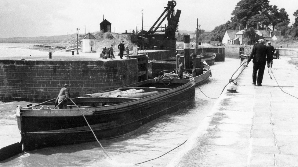 Black and white image of a barge entering Lydney Harbour