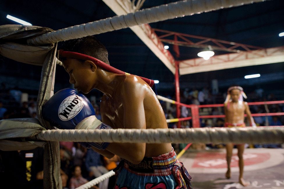 This picture taken on June 28, 2012 shows a young Muay Thai boxer paying his respects to the ring at a boxing stadium
