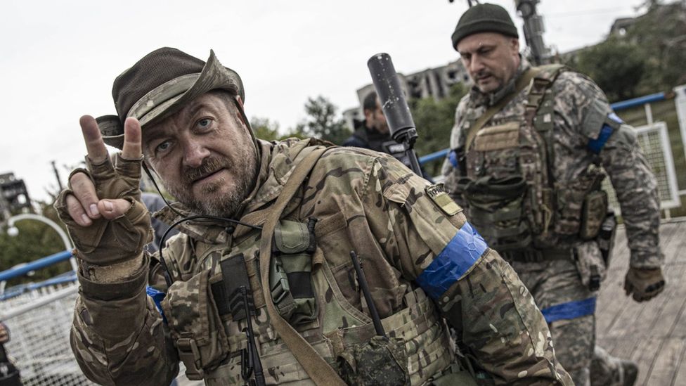 A Ukrainian soldier makes a victory sign while on patrol of Izium