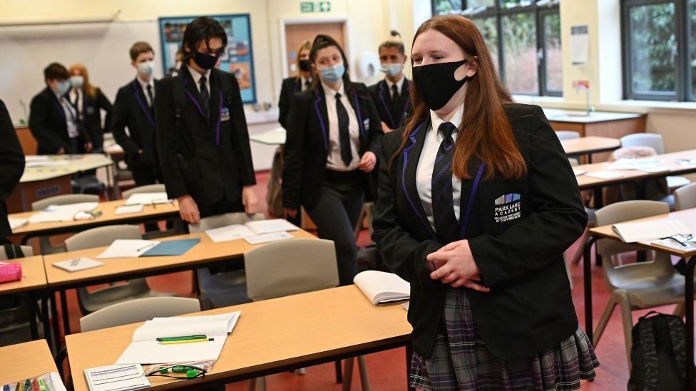 Year 11 students, wearing face coverings, leave their classroom before taking a lateral flow Covid-19 test in the Sports Hall at Park Lane Academy in Halifax, England, March 8
