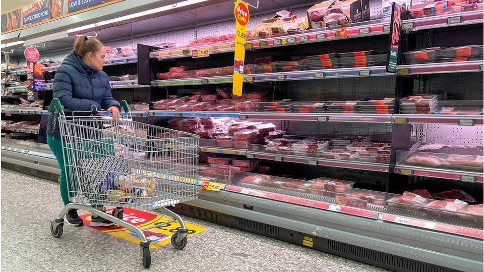 Woman looking at meat in supermarket