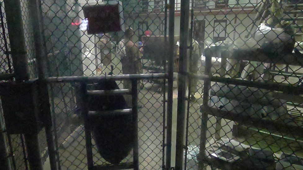 Detainees - shown behind a fence