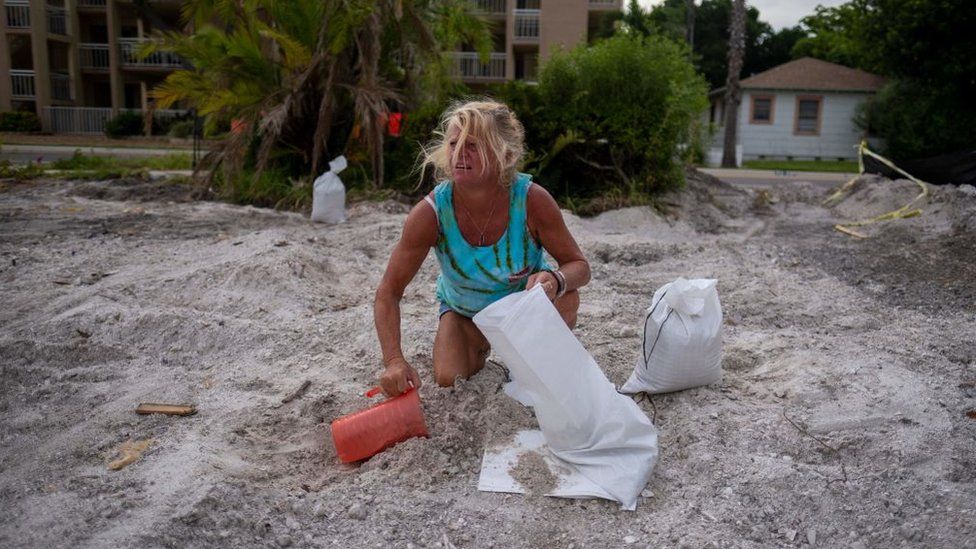 Barbara Schueler fills sandbags in a vacant lot in preparation for Hurricane Ian in St. Pete Beach, Florida on September 26, 2022