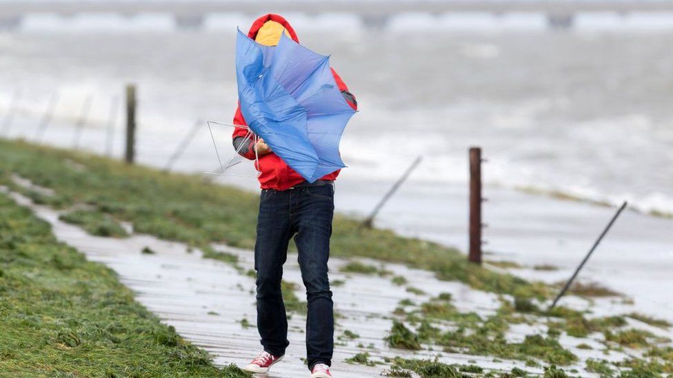 Man battling with an umbrella in the wind