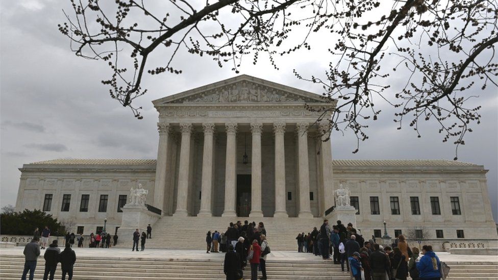 People wait in line outside the U.S. Supreme Court to hear the orders being issued, in Washington