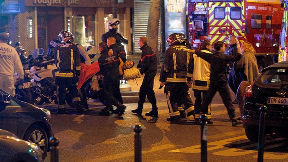 Medics move a wounded man near the Boulevard des Filles-du-Calvaire after an attack in November, 2015 in Paris, France