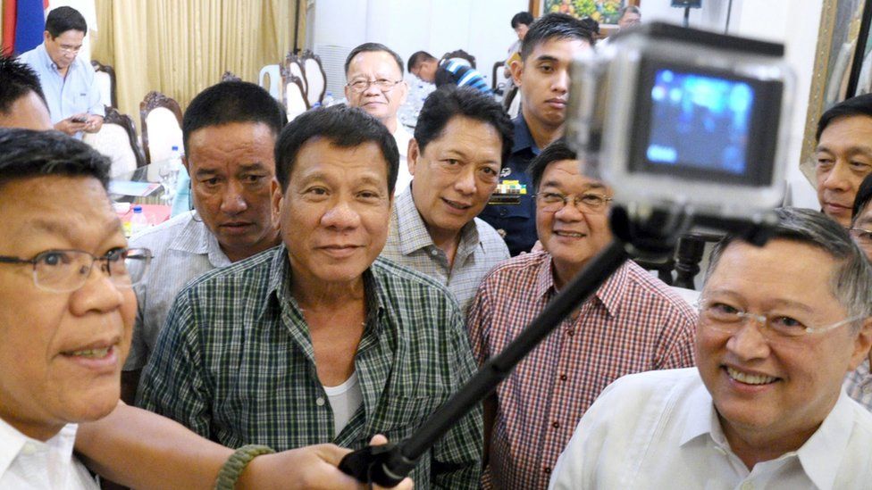 Filipino President-elect Rodrigo Duterte (centre), surrounded by a large group of male cabinet members, posing for a selfie in Davao City on 31 May 2016.