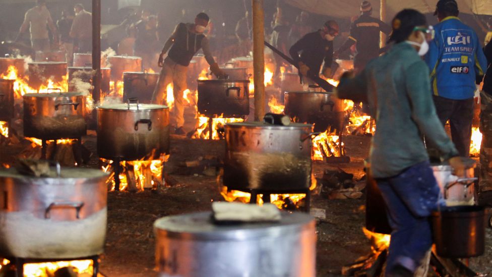 People overseeing many pots cooking over open fires in Cape Town, South Africa - Monday 2 May 2022