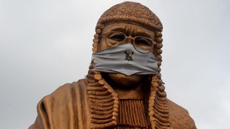 The statue of late lawyer and rights activist Gani Fawehinmi wears a face mask at the Liberty Park at Ojota in Lagos, on July 27, 2020. - The 34-feet statue to immortalise the fiery lawyer and rights advocate is being used to sensitise people to the sanitary measures taken to curb the spread of the COVID-19 pandemic in Lagos, Nigeria's commercial hub and epicentre of the virus in the country.