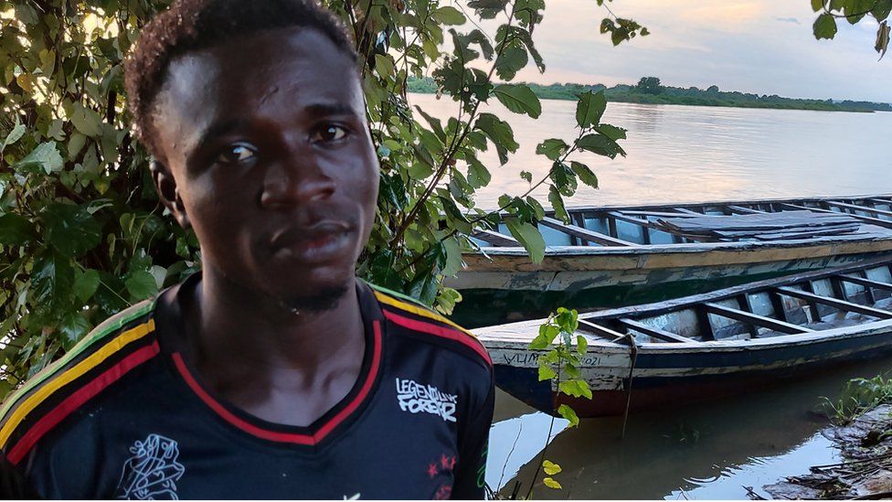 Mohammed Alhassan at the river bank in front of canoes