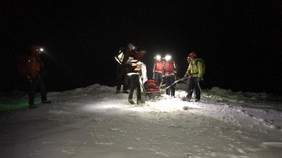 Llanberis Mountain Rescue workers carrying an injured man