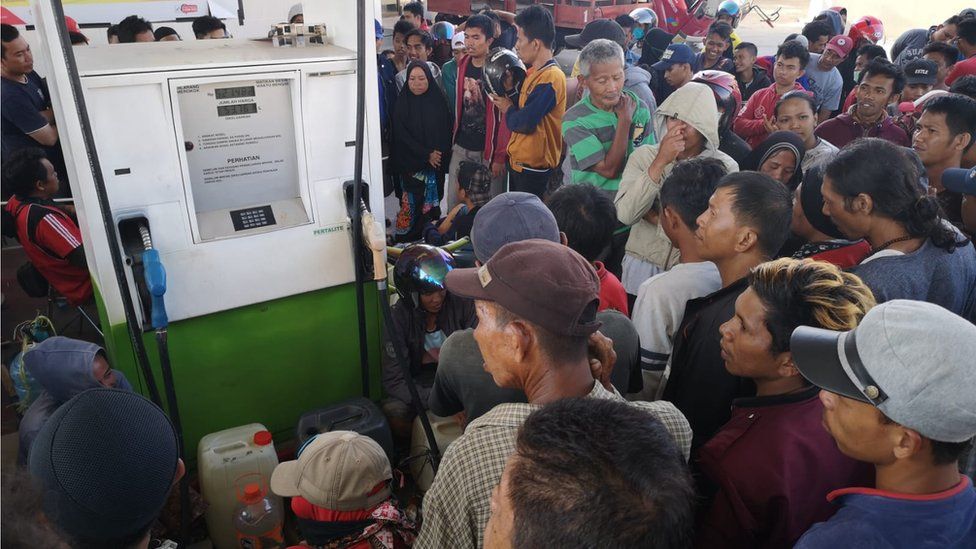 People crowd around a petrol pump in Palu