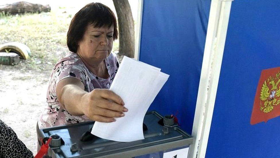 A woman casts her ballot at a mobile polling station in Donetsk