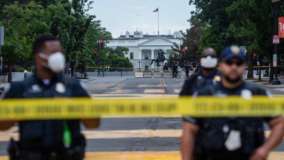 Police officers stand behind a police line as they block a road in "Black Lives Matter" plaza near the White House in Washington, DC on June 24, 2020.