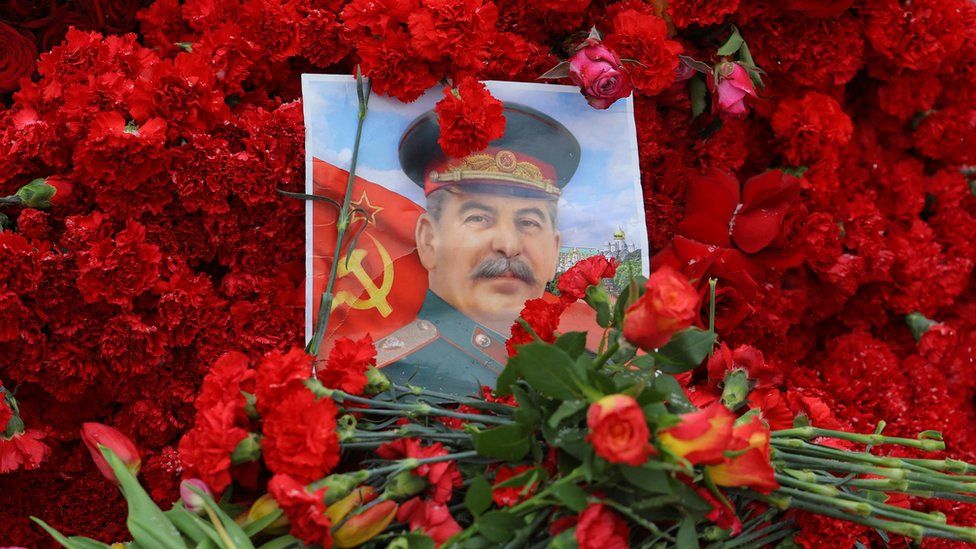 A picture of Joseph Stalin surrounded by red carnations