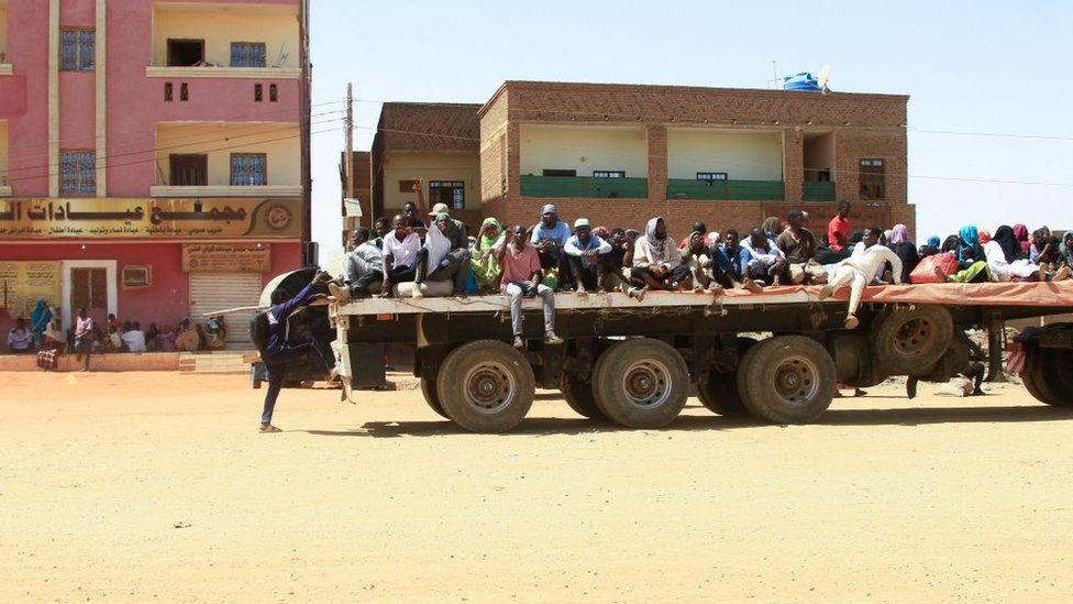 People fleeing Khartoum on flatbed trucks