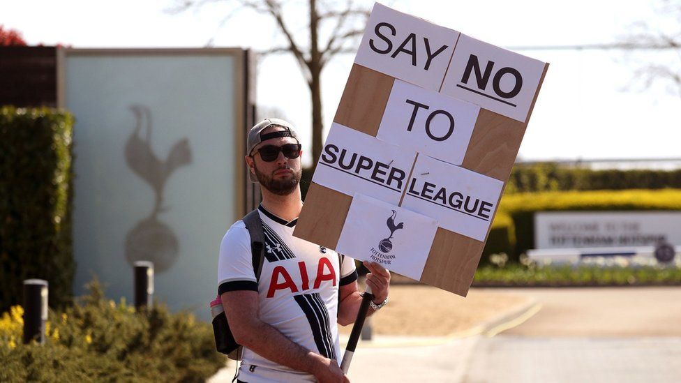 A Tottenham Hotspur fan holds a placard saying: "No to Super League"