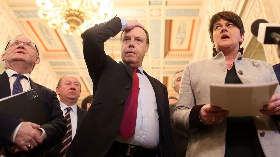 DUP deputy leader Nigel Dodds (centre) gestures as DUP leader Arlene Foster (r) speaks to members of the media in the Great Hall at Stormont
