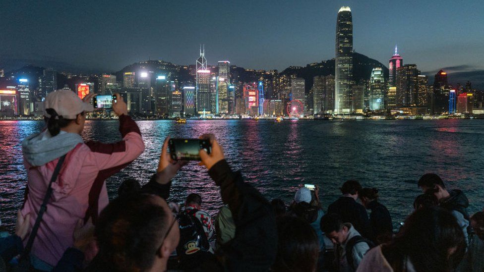 Tourists along the Tsim Sha Tsui promenade during the Lunar New Year holiday in Hong Kong