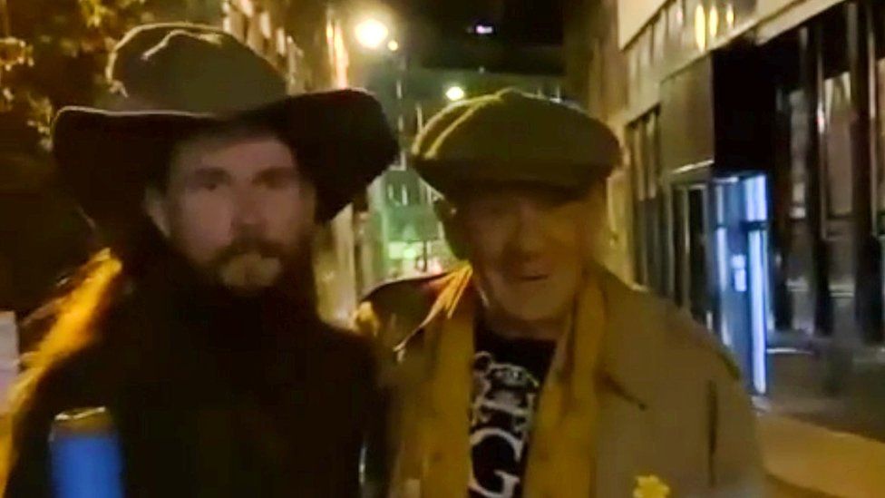 Actor Ian McKellen poses for a video with fan dressed as Gandalf