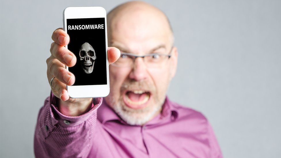 Angry man showing smartphone infected with ransomware